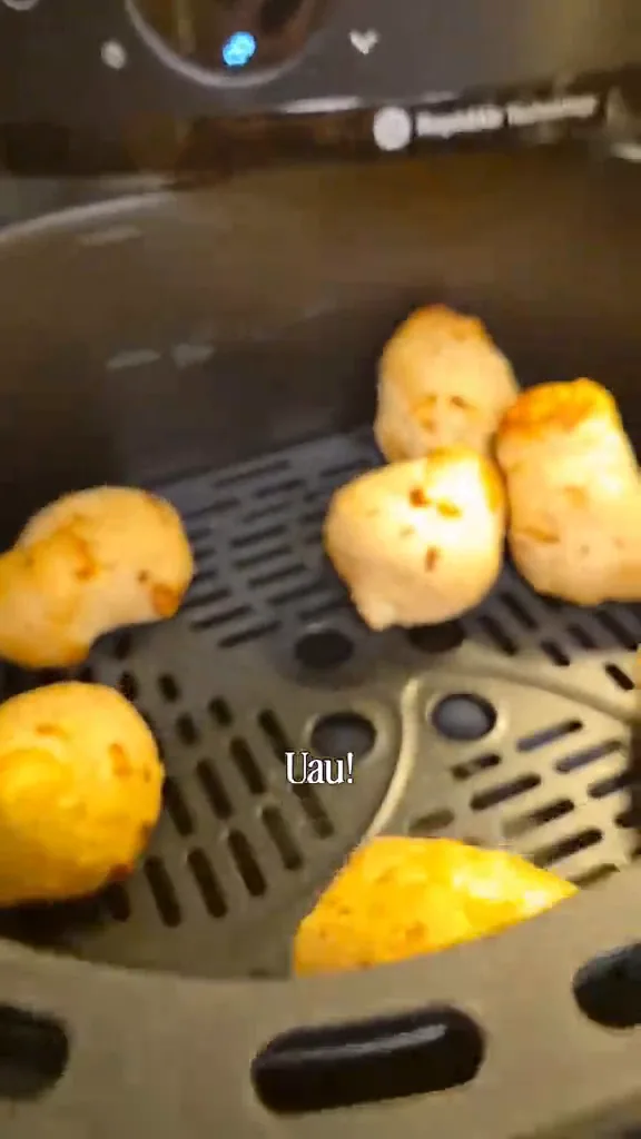 Cesto da fritadeira elétrica aberto com alimentos dourados recém-assados