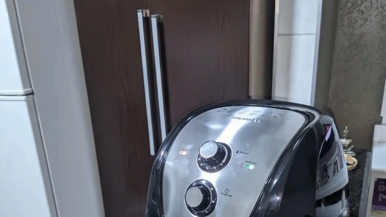 Fritadeira Mondial em funcionamento com luz piloto acesa na cozinha
