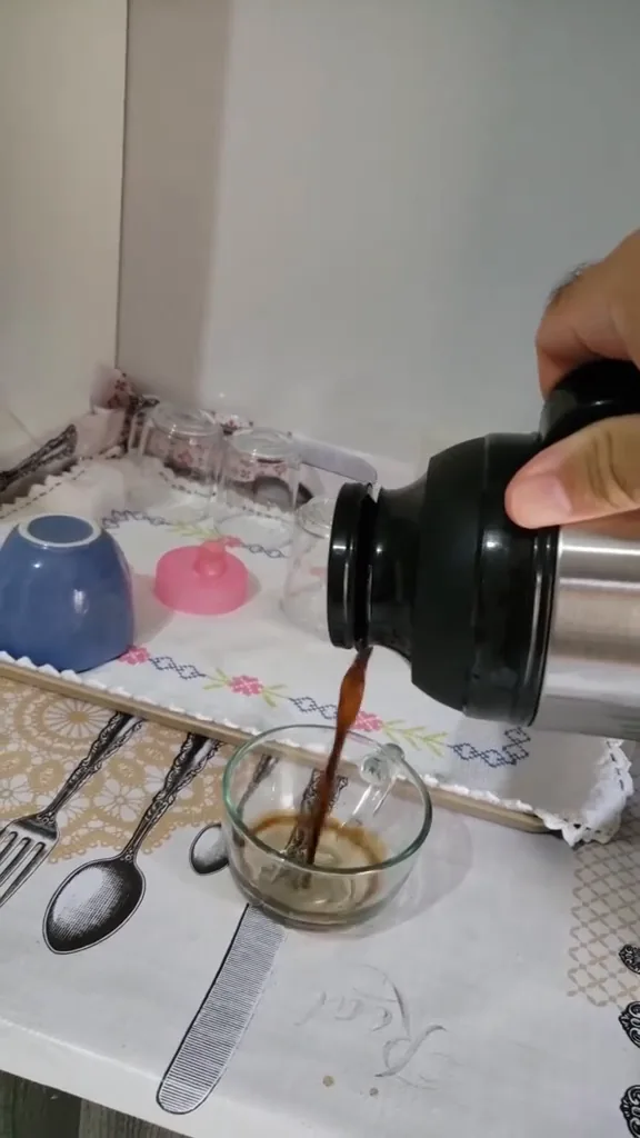 Servindo café quente na xícara com a garrafa térmica Termolar
