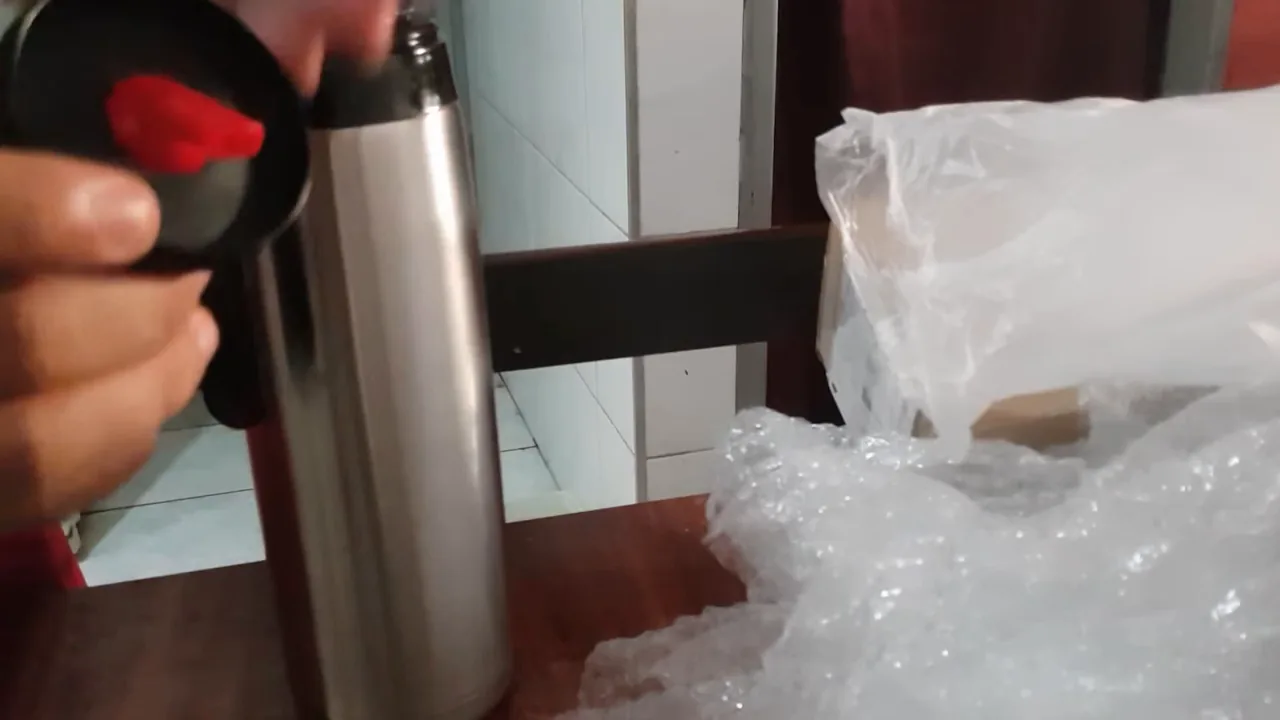 Mecanismo da rolha Click Mate da garrafa térmica sendo demonstrado manualmente