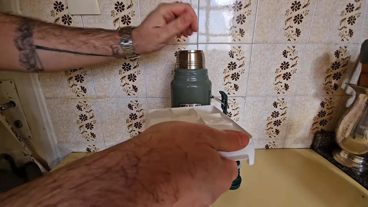 Colocando pedras de gelo na garrafa térmica Stanley Classic