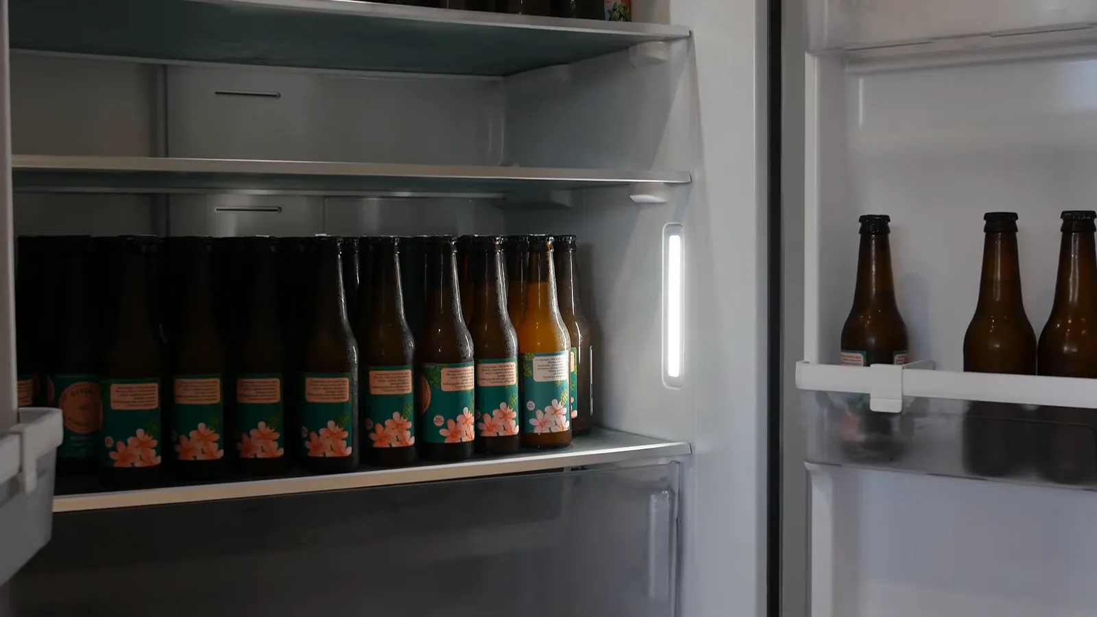Interior iluminado do refrigerador com prateleiras de vidro temperado e garrafas