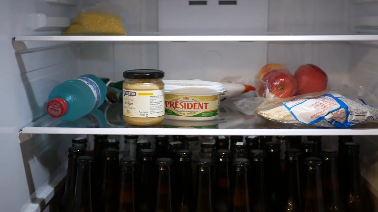 Prateleiras do refrigerador organizadas com diversos alimentos e bebidas