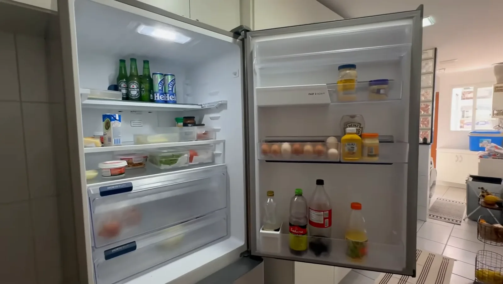 Interior iluminado do refrigerador com prateleiras ajustáveis e alimentos organizados