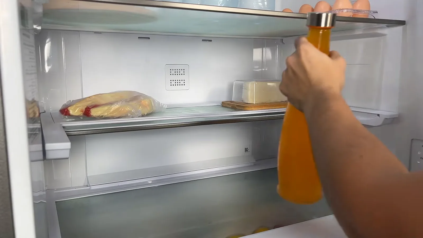 Prateleira retrátil recolhida para acomodar garrafas altas no refrigerador