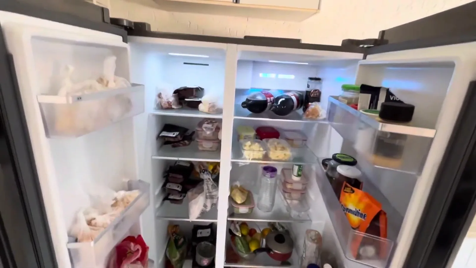 Portas abertas destacando compartimentos internos do freezer e refrigerador side by side