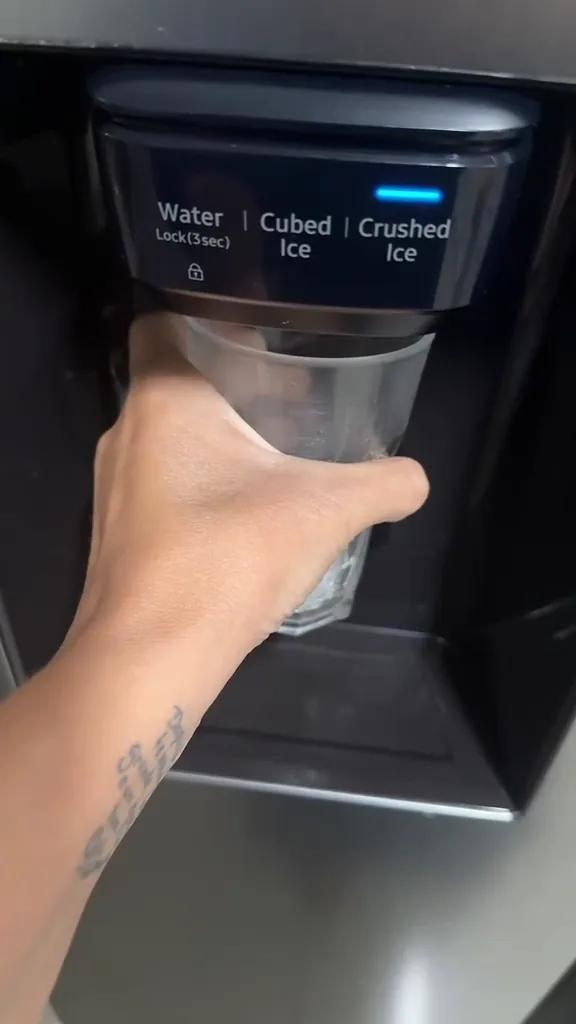 Dispenser frontal da geladeira despejando gelo triturado no copo