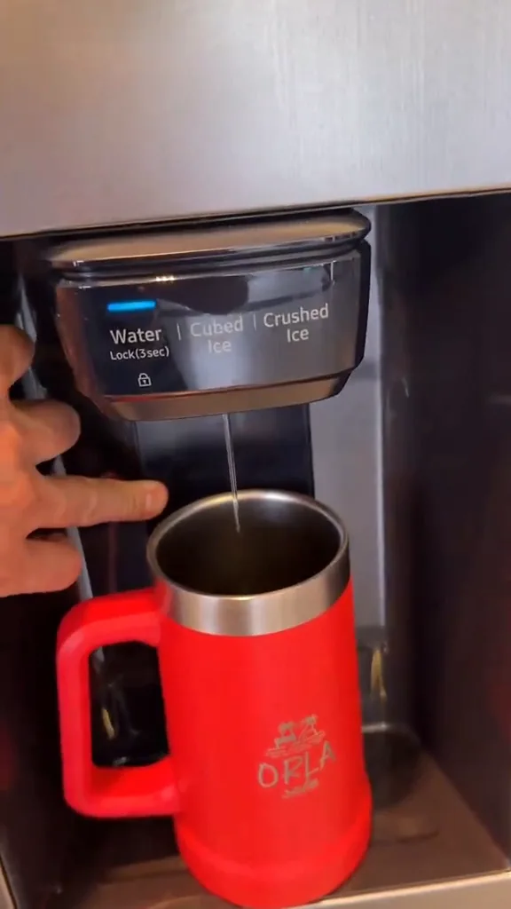 Dispenser da geladeira Samsung despejando água diretamente no copo térmico