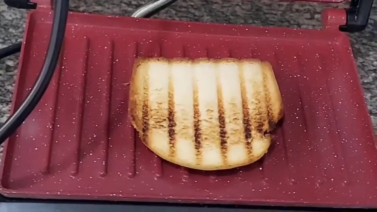 Abertura do grill revelando fatia de pão perfeitamente tostada