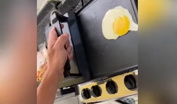 Tampa superior prensando os hambúrgueres na chapa ondulada do grill