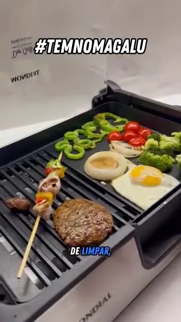 Virando carnes e legumes na chapa dupla do grill elétrico