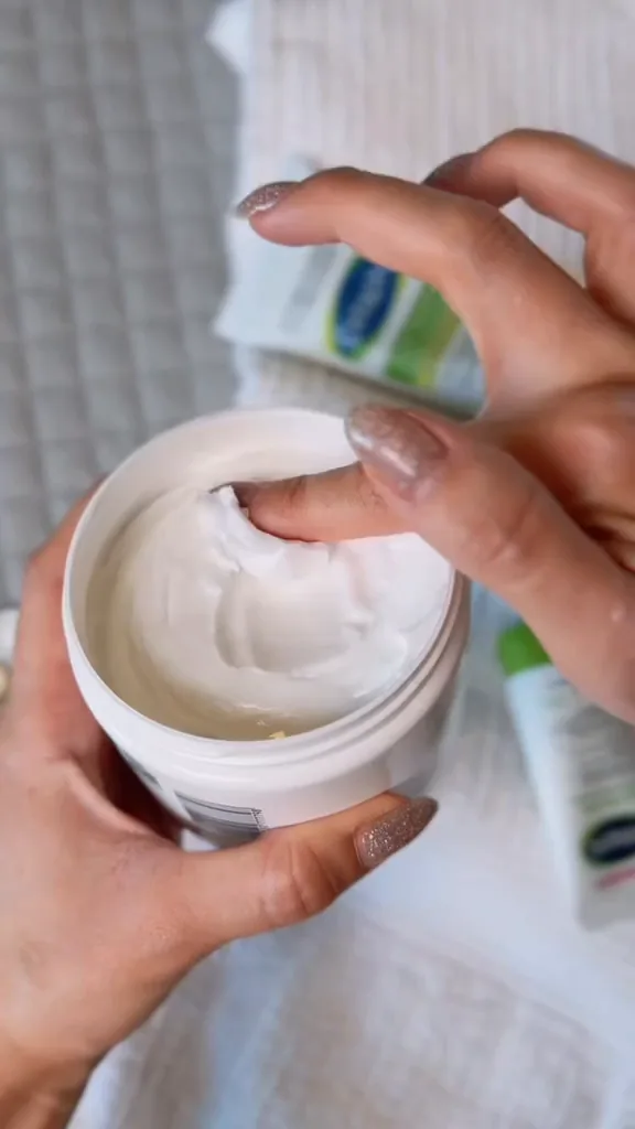 Textura densa do creme hidratante Cetaphil sendo retirada do pote