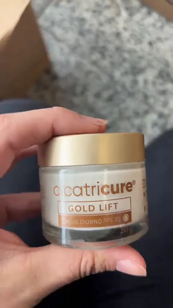 Manuseio do pote do creme facial Cicatricure Gold Lift diurno