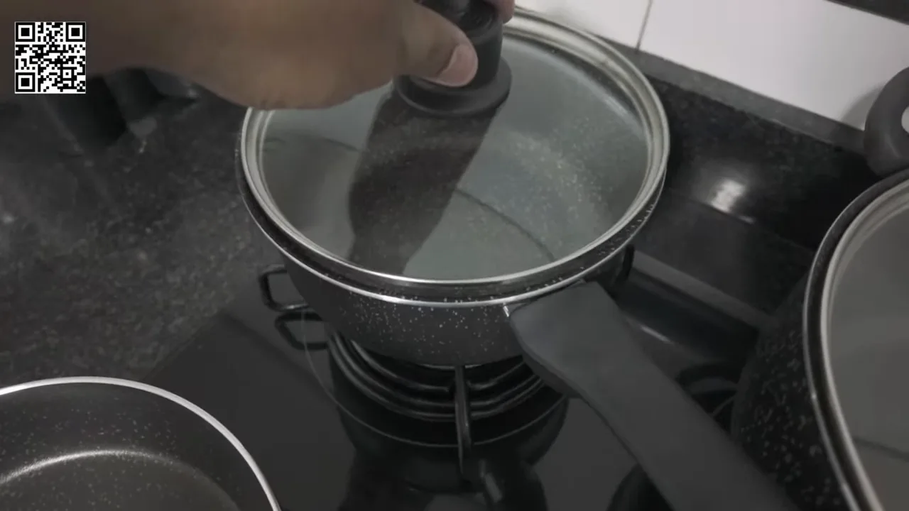 Levantando a tampa de vidro da panela com água fervendo