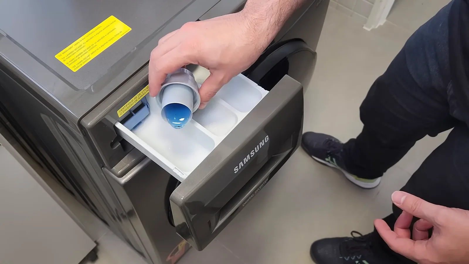 Abastecendo dispenser com sabão líquido na lava e seca Samsung