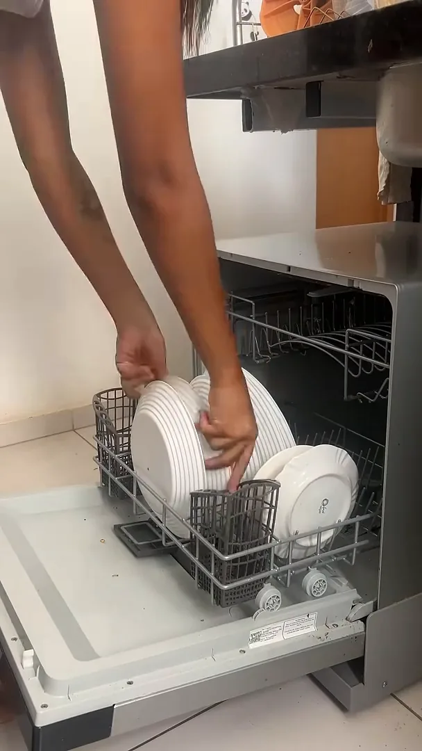 Cesto inferior da lava-louças com pratos e talheres organizados