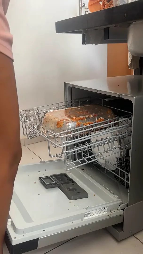 Cesto superior da lava-louças acomodando travessa de vidro e copos