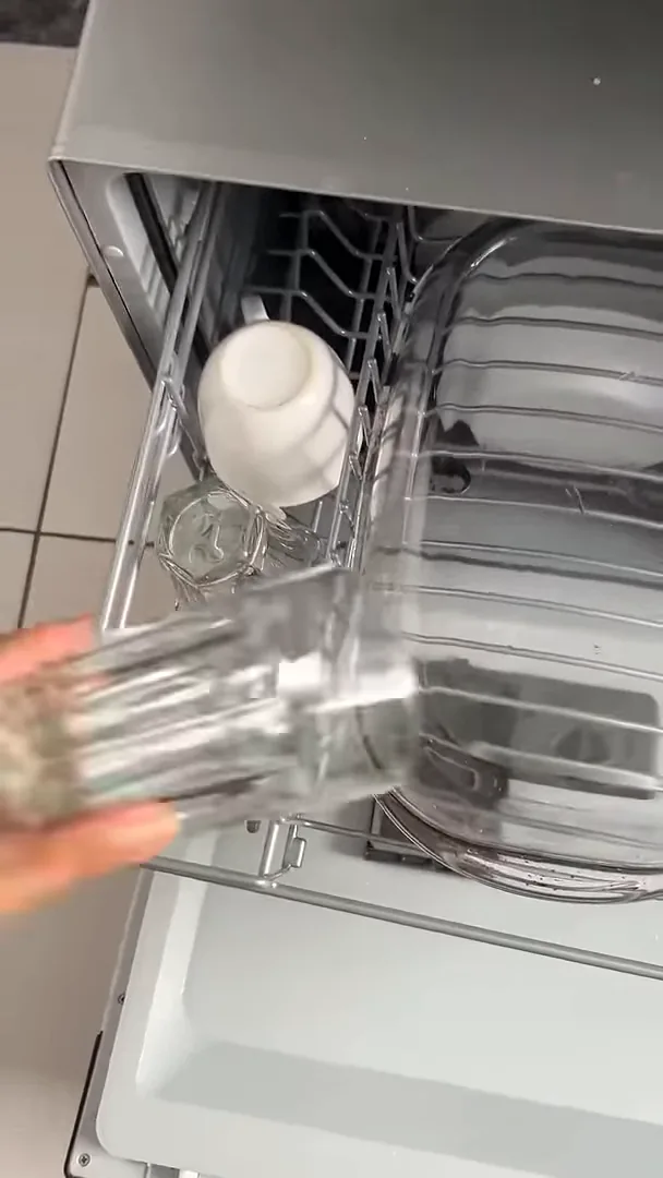 Retirada de louças perfeitamente limpas do cesto superior da máquina