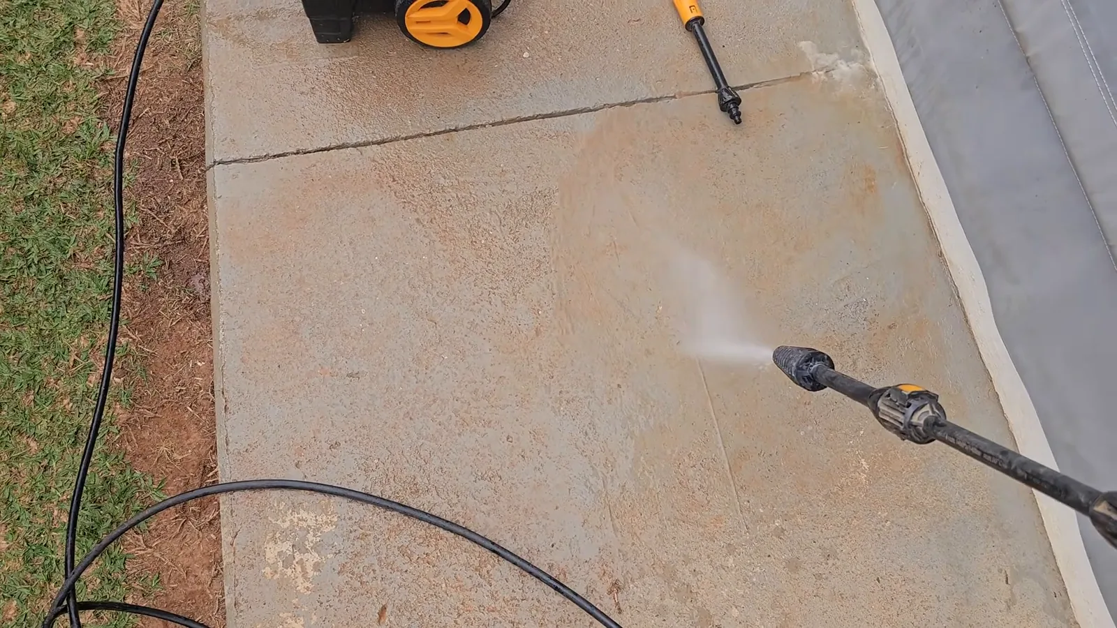 Jato giratório da lavadora decapando a superfície da calçada de concreto