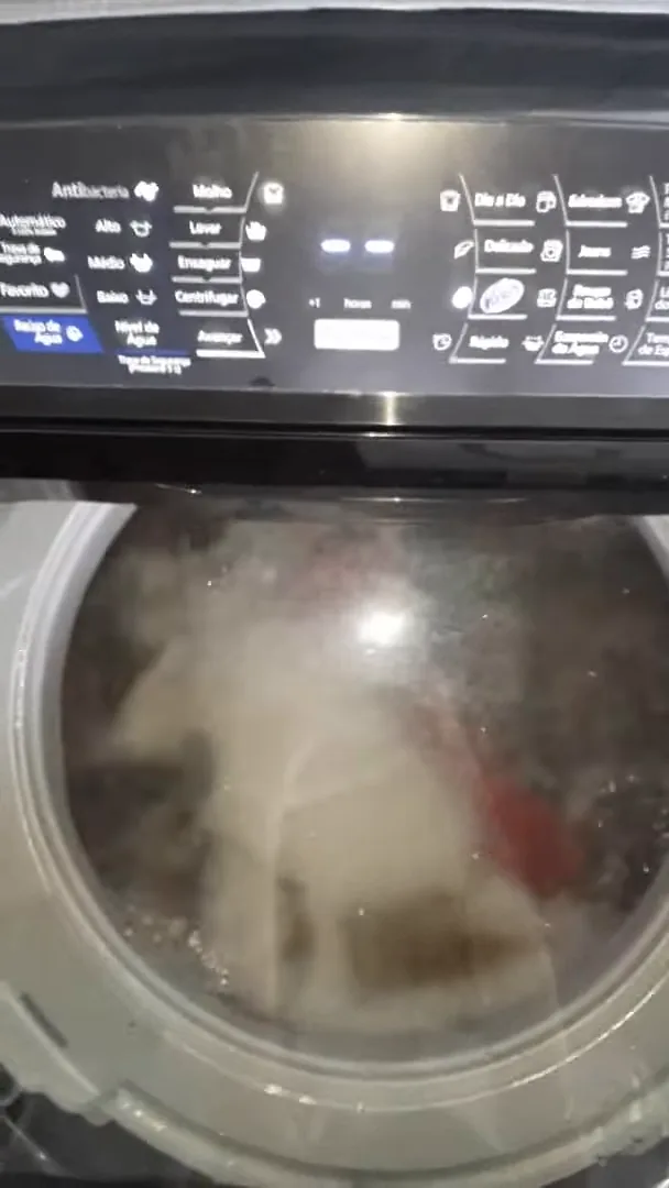 Lavadora Panasonic operando com intensa movimentação de roupas e espuma
