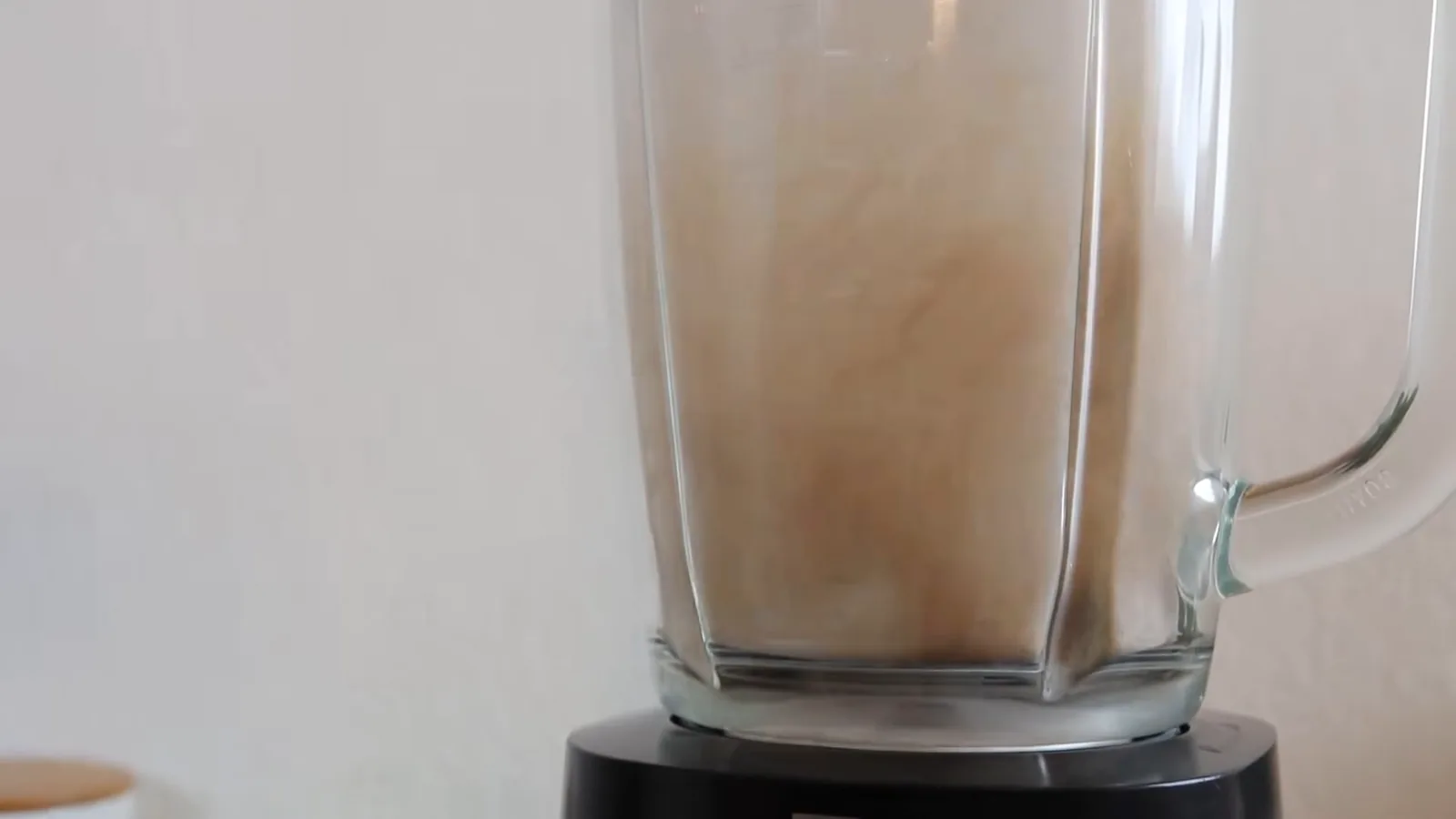 Liquidificador potente triturando grãos secos no copo de vidro borossilicato