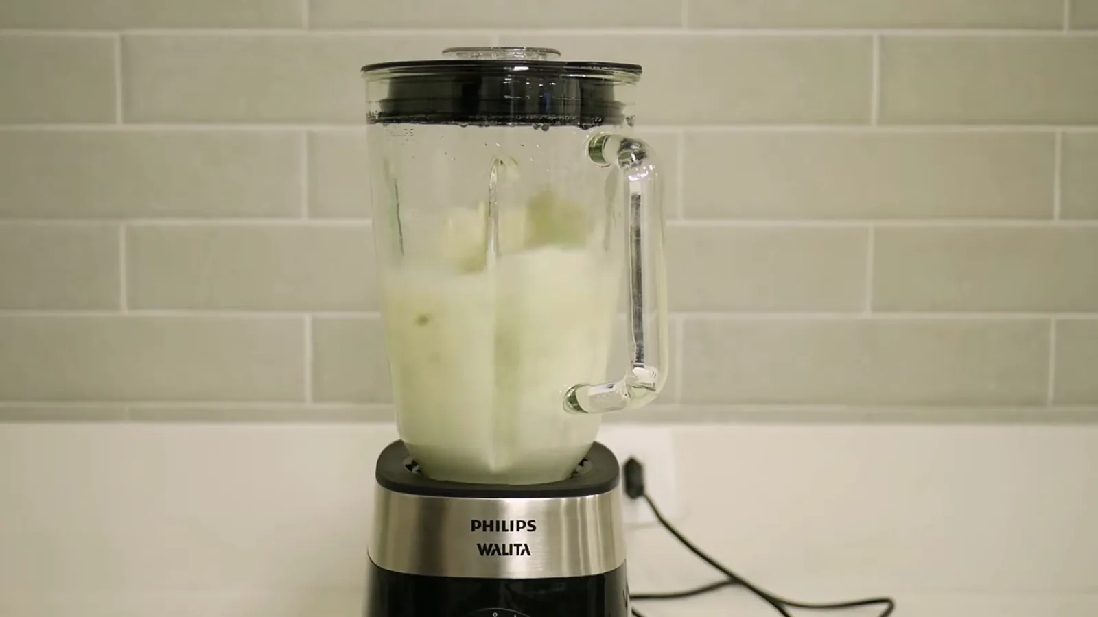 Liquidificador Philips Walita batendo suco no copo de vidro