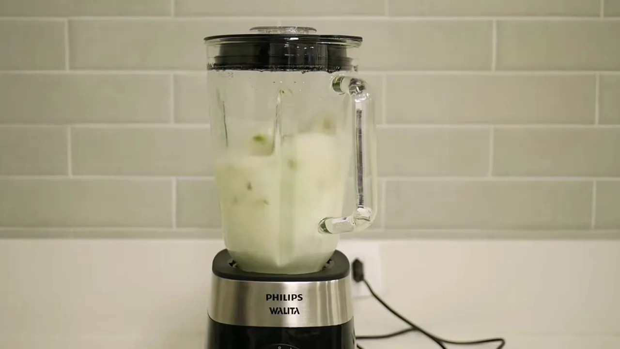 Liquidificador com copo de vidro batendo líquidos em alta rotação
