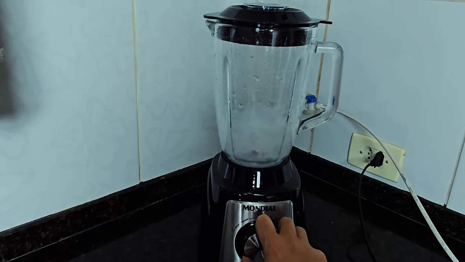 Liquidificador Mondial triturando gelo com água na jarra de vidro
