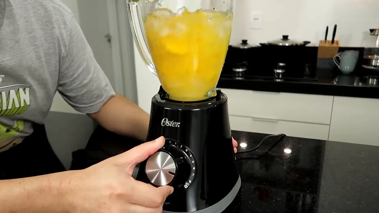 Liquidificador Oster triturando pedras de gelo com pedaços de manga