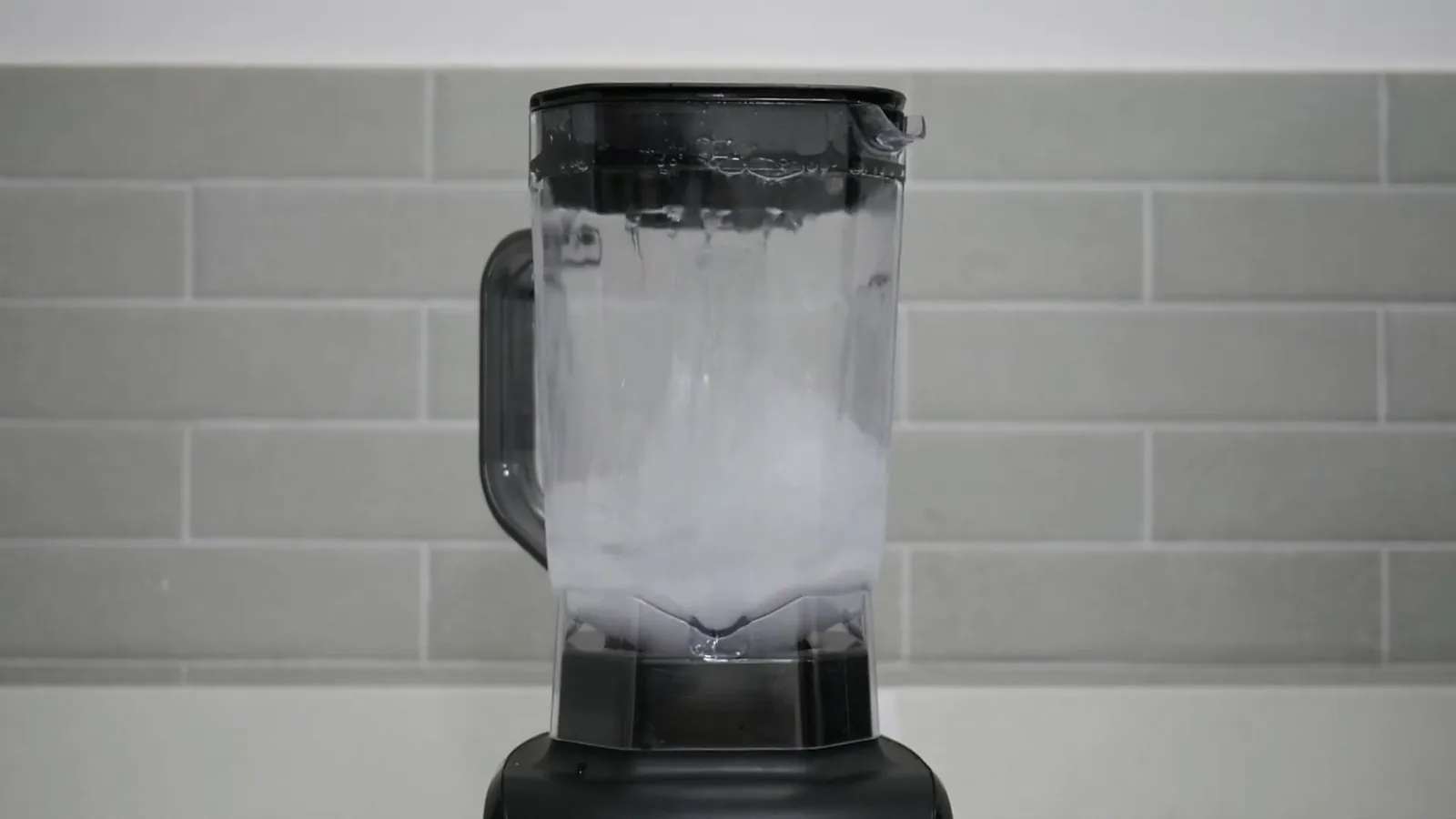 Liquidificador Oster OLIQ610 batendo líquidos em alta potência na bancada
