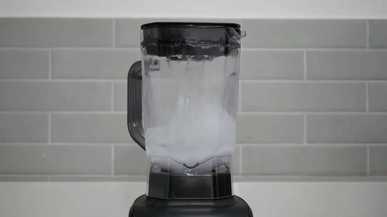 Liquidificador Oster funcionando com líquido em teste de vedação e velocidade