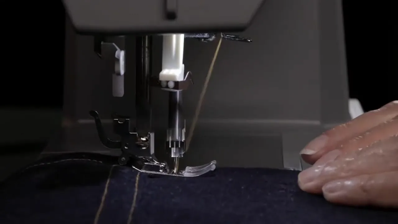 Máquina costurando tecido jeans com ponto reforçado e firme