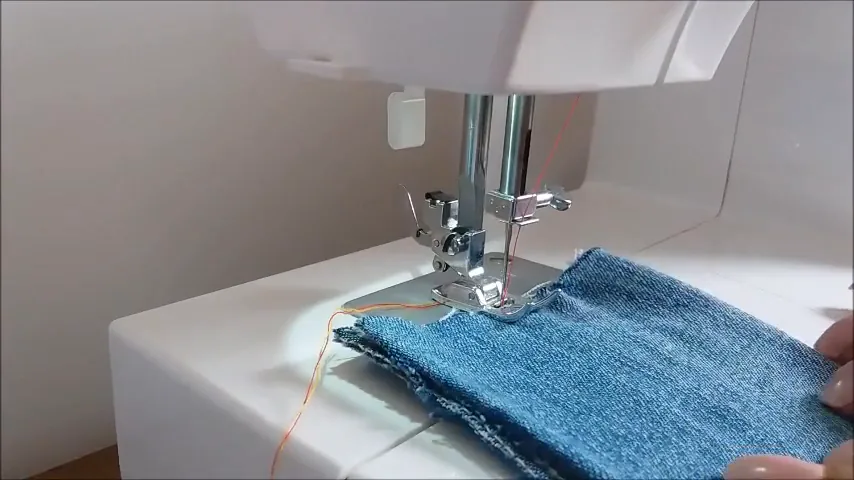 Máquina de costura costurando camada dupla de tecido jeans