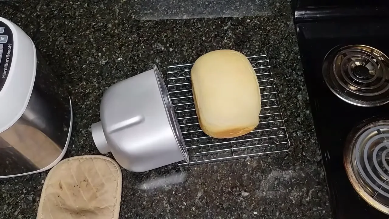 Pão caseiro assado desenformado ao lado da máquina Hamilton Beach