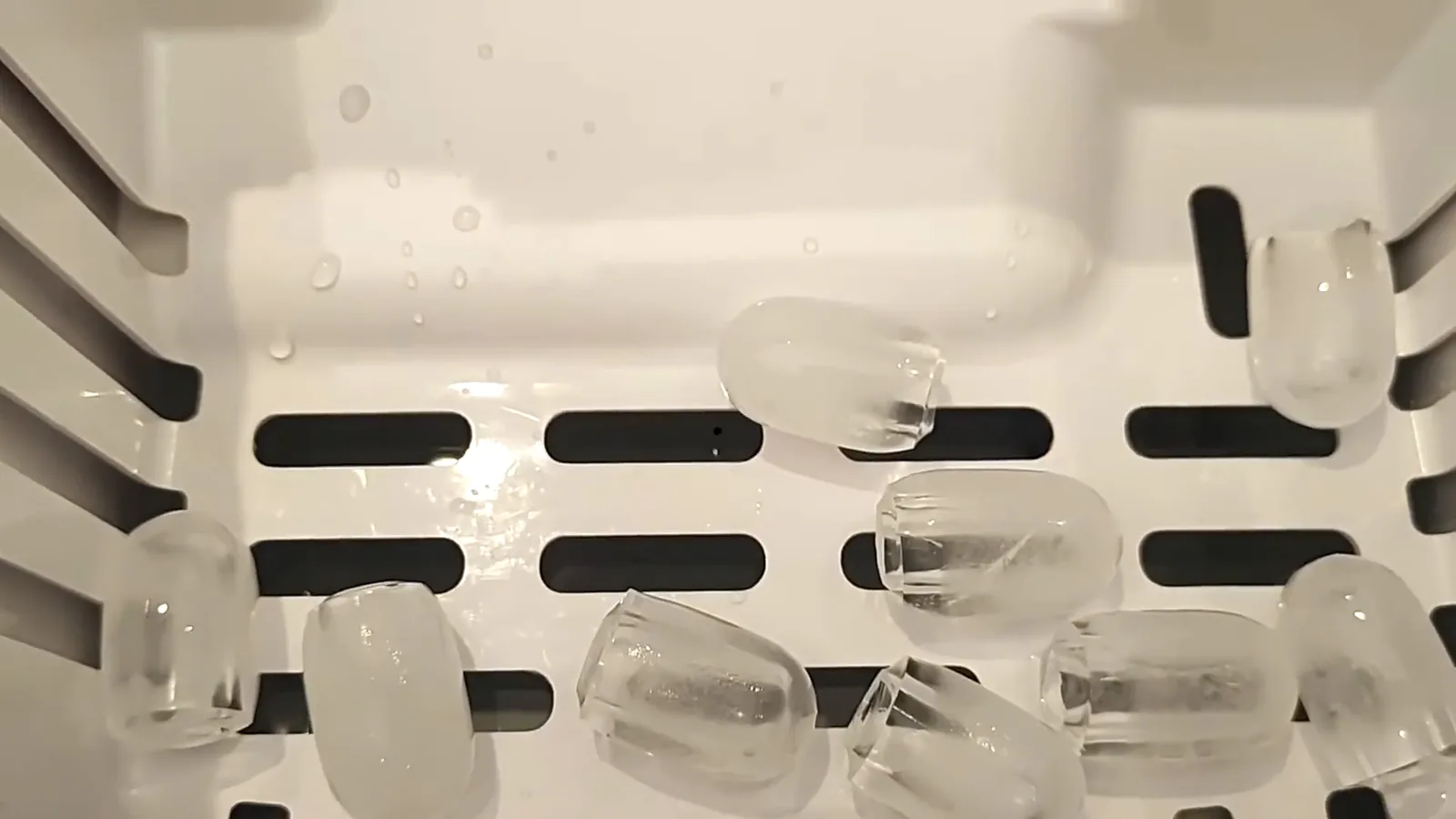 Cubos de gelo recém-produzidos acumulados no cesto da máquina