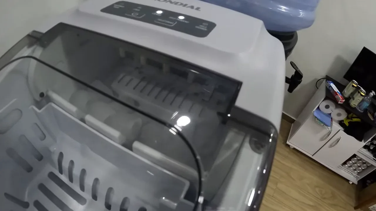 Mecanismo interno ejetando os cubos de gelo no cesto coletor