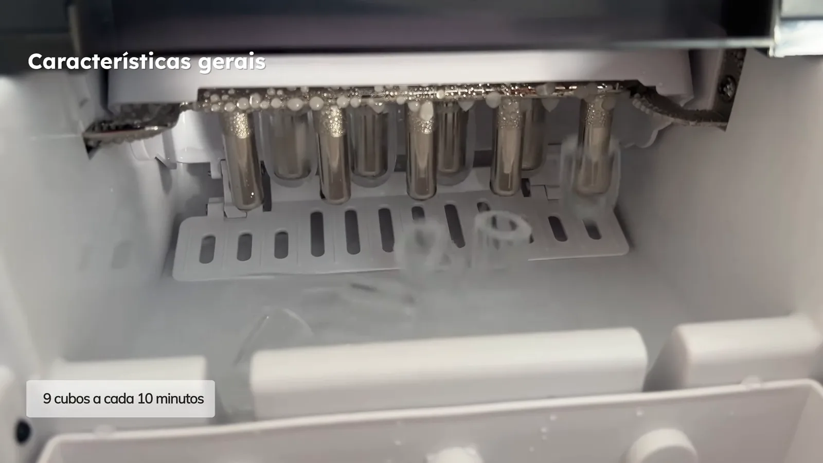 Compartimento interno da máquina produzindo cubos de gelo