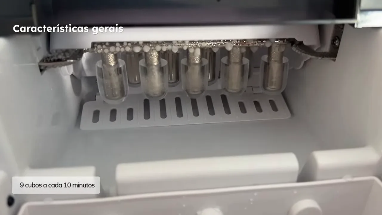 Mecanismo interno descarregando cubos de gelo recém-produzidos no cesto