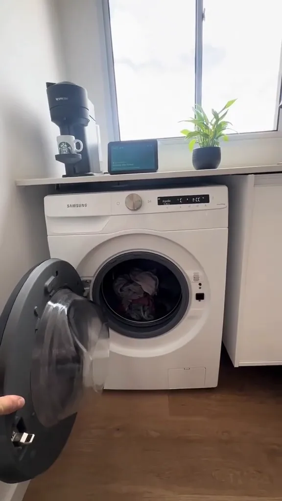 Máquina Samsung com tambor abastecido de roupas para lavagem