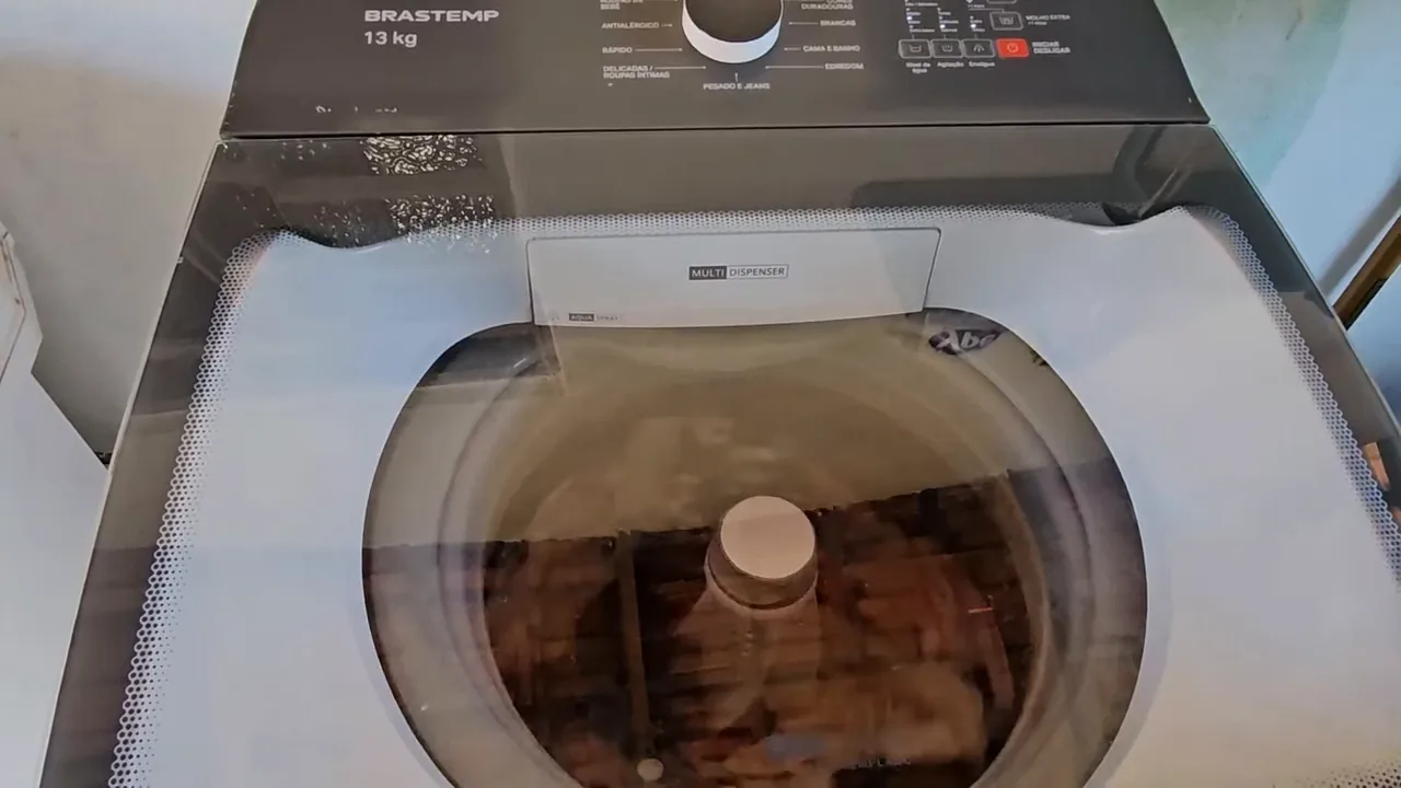 Máquina de lavar Brastemp funcionando e agitando roupas durante a lavagem