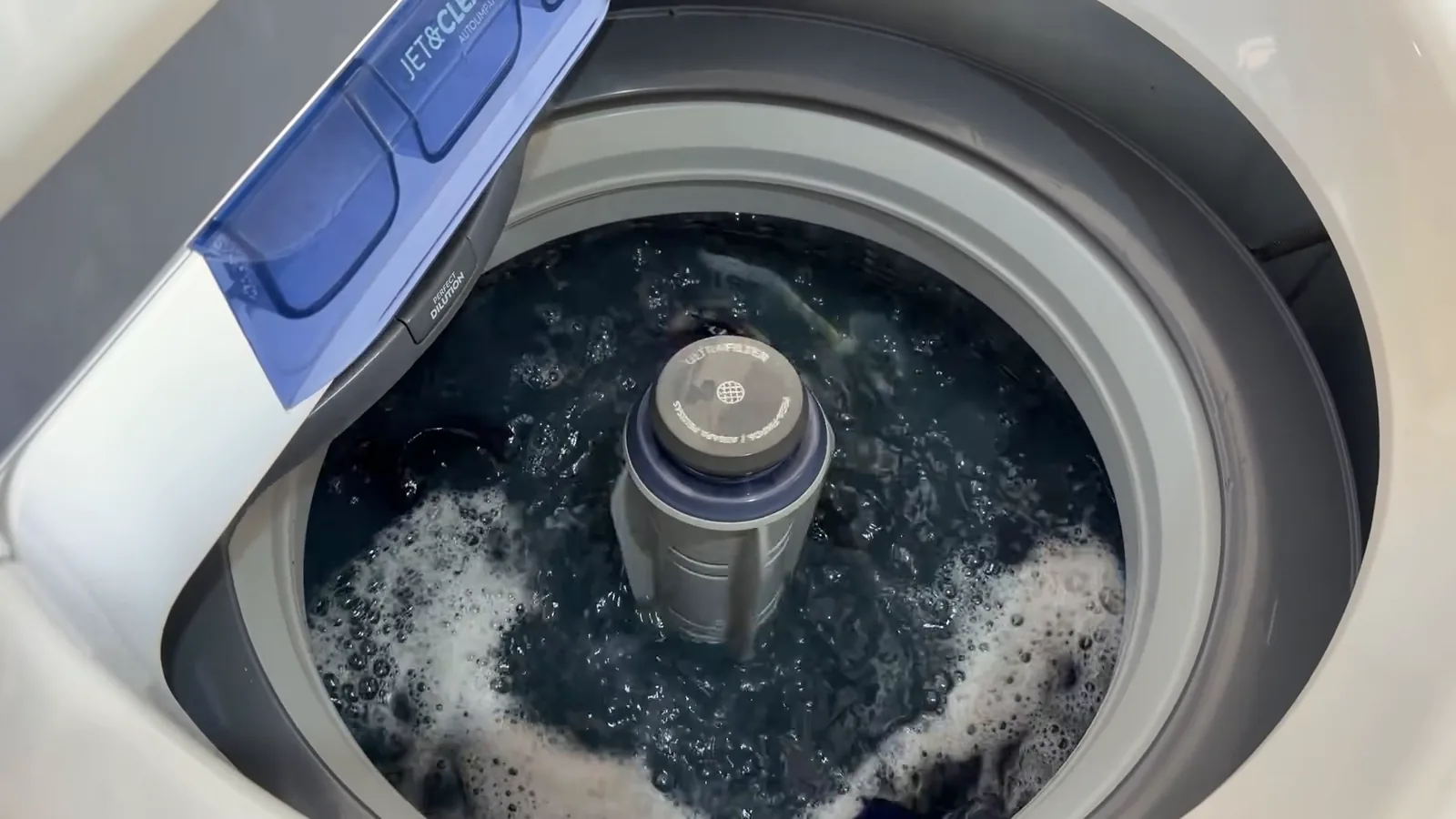 Máquina Electrolux LED15 em ciclo de agitação lavando roupas escuras