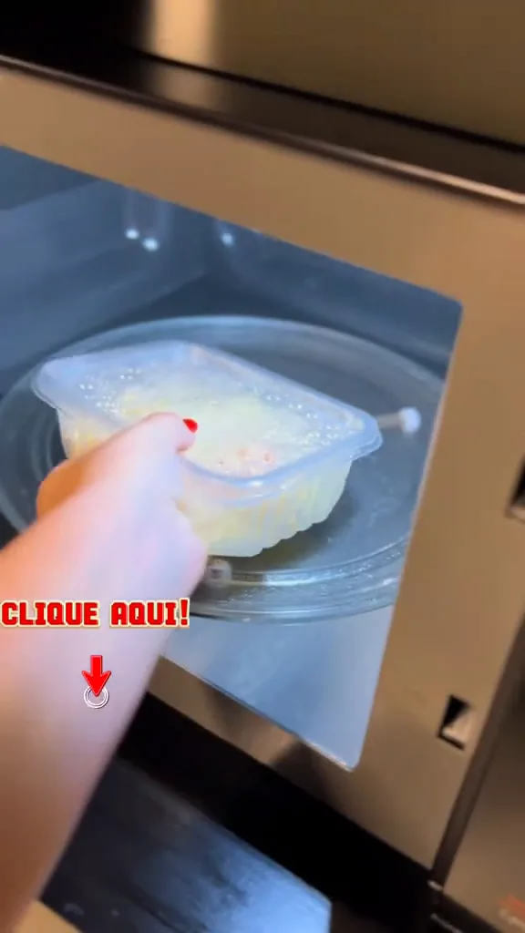 Inserindo pote de alimento na cavidade interna iluminada do micro-ondas