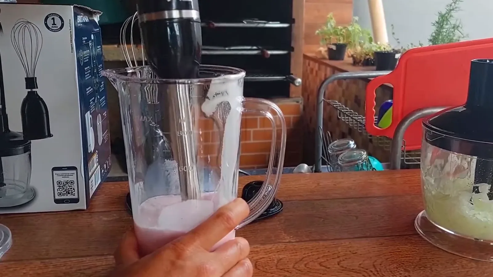 Haste do mixer preparando milkshake de morango no copo