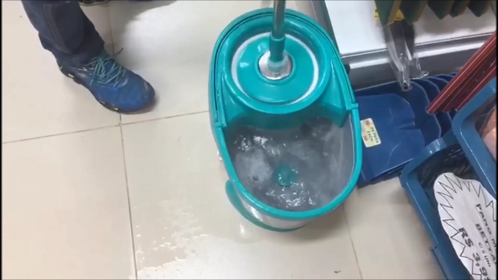 Refil do mop girando na água do balde para lavagem
