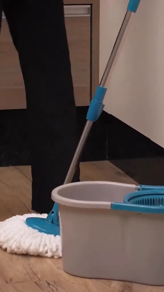 Passando o mop giratório no piso ao lado do balde