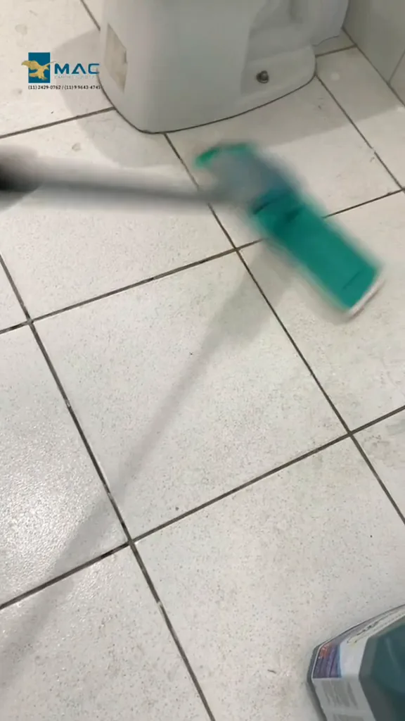 Mop spray higienizando o piso cerâmico próximo ao vaso sanitário