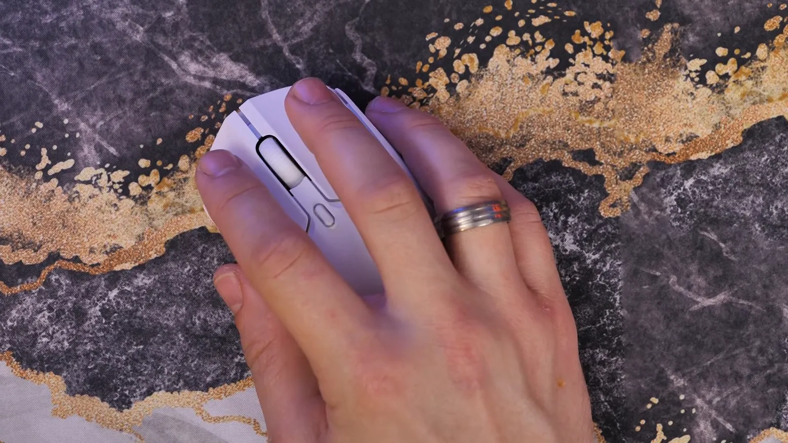 Usuário segurando o mouse gamer sem fio sobre o mousepad