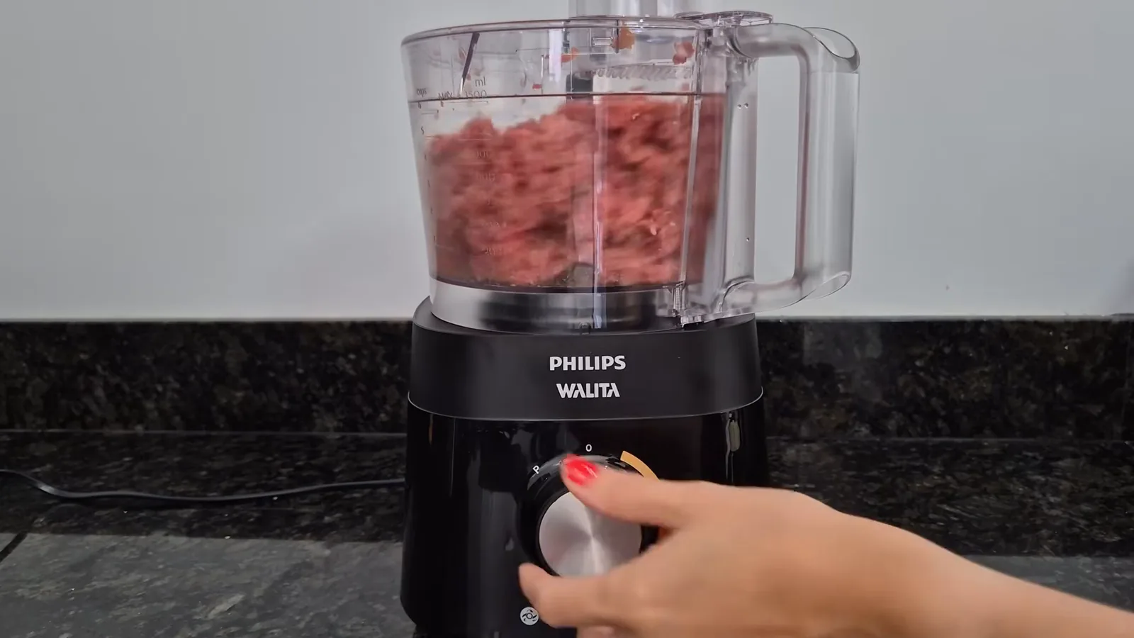 Multiprocessador moendo carne crua com a lâmina de corte