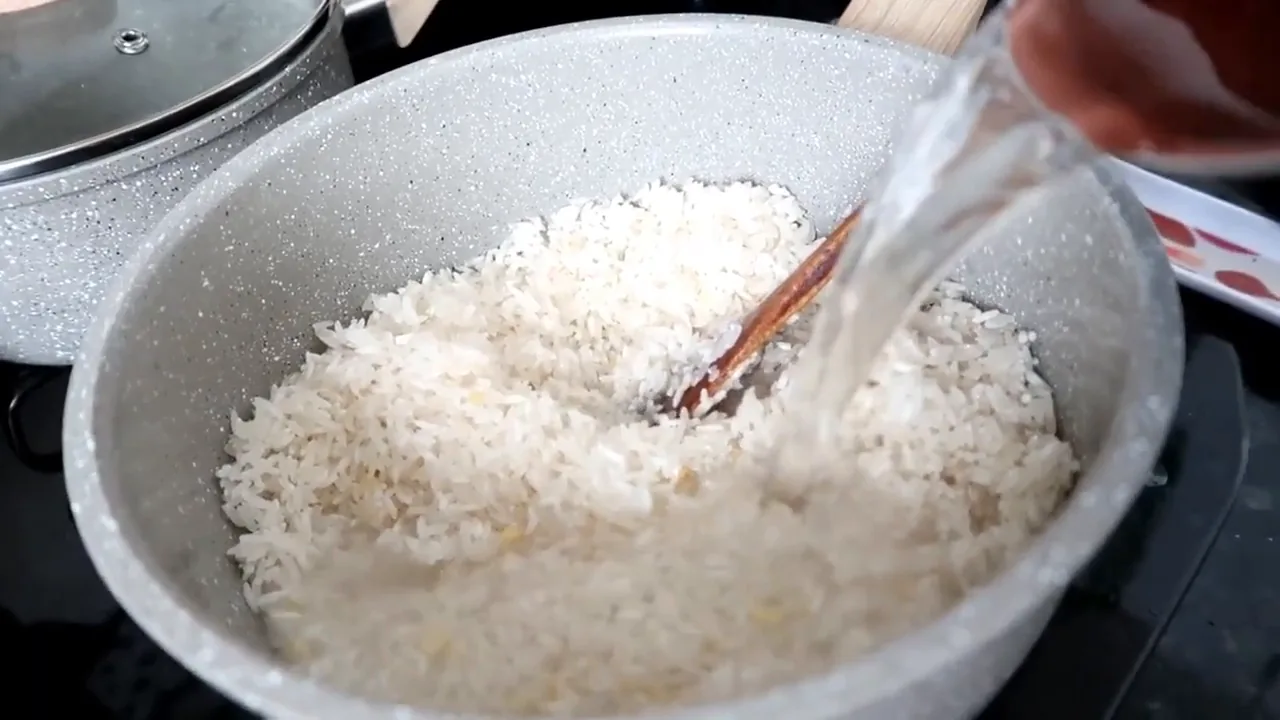 Adicionando água ao arroz na panela Oster Marble Edition