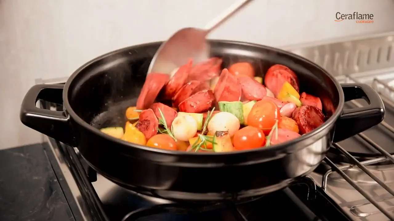Panela de cerâmica Ceraflame refogando legumes e linguiça no fogão